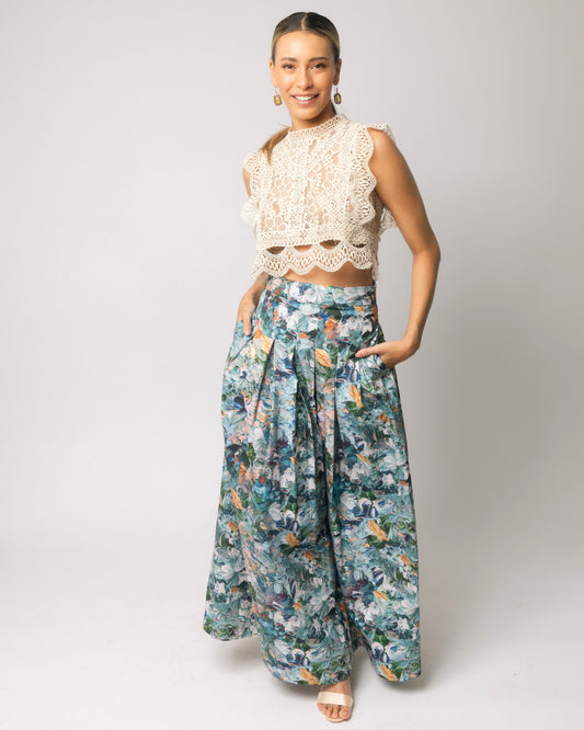 Woman wearing a lace top and floral maxi skirt on a white background