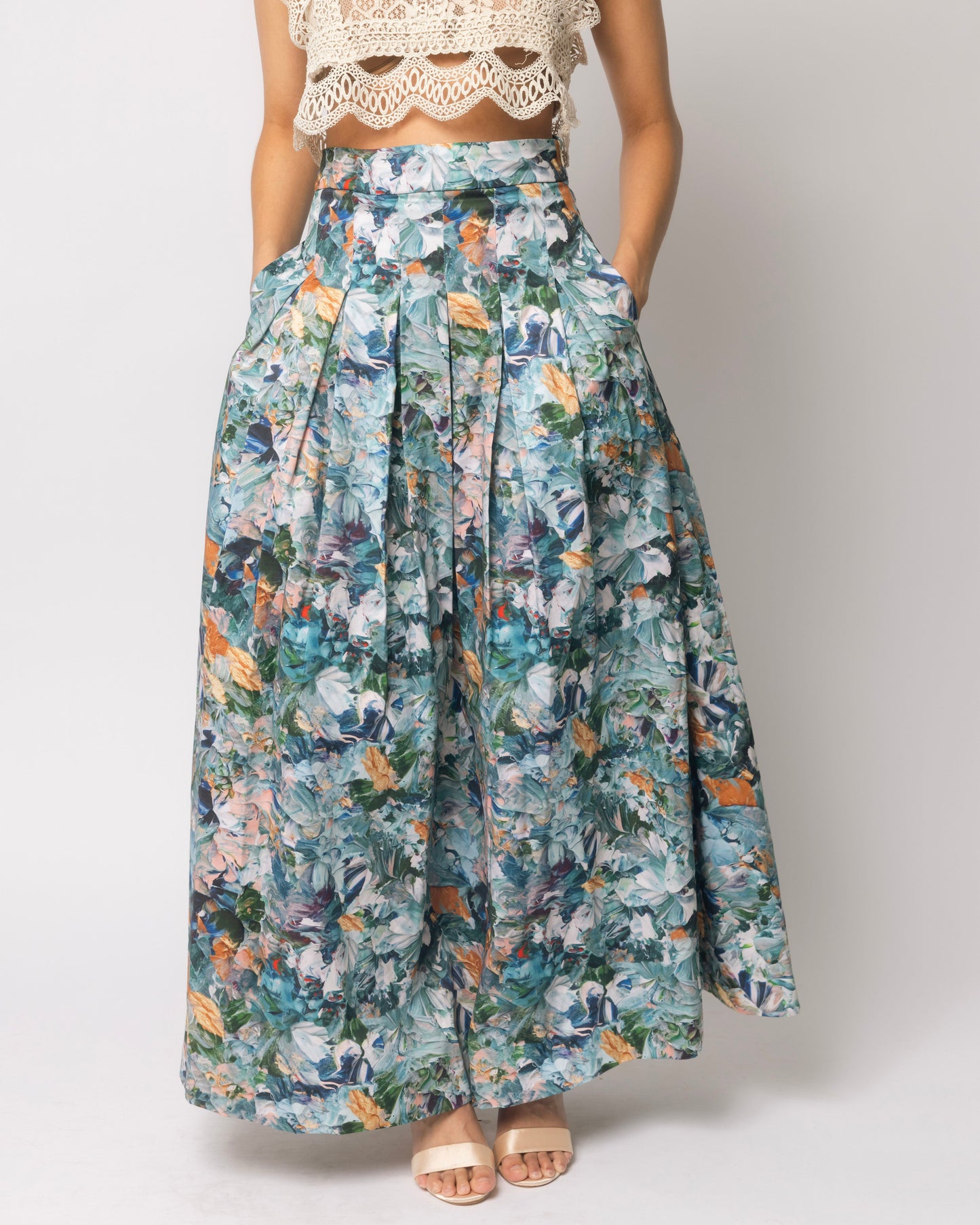 Person wearing a floral skirt and lace top on a white background