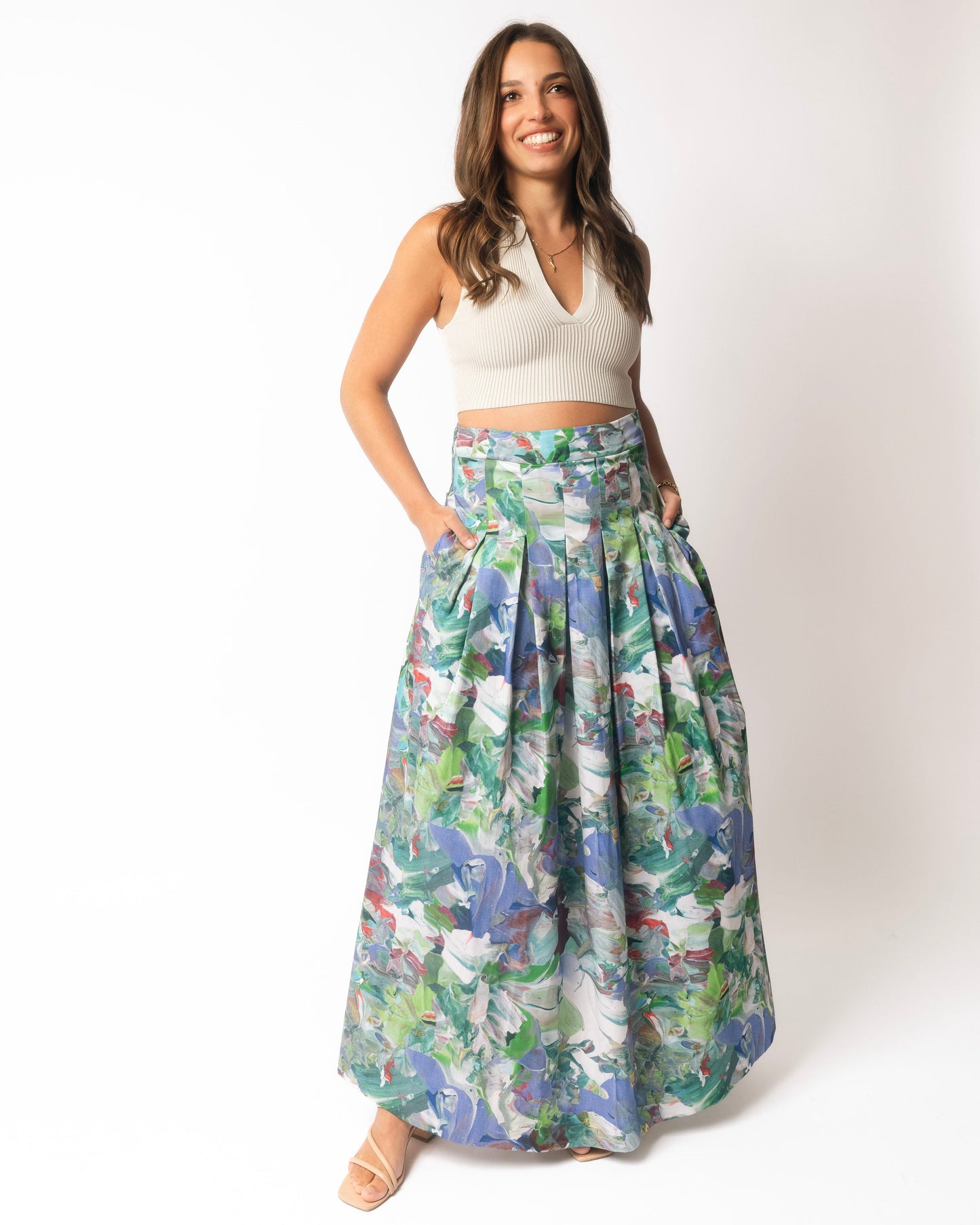 Woman wearing a floral skirt and white top on a white background