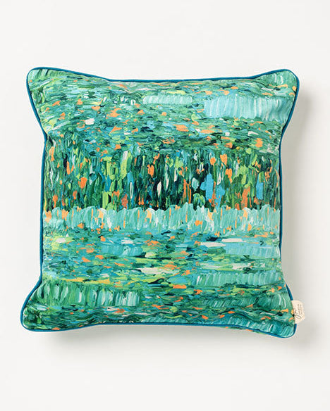 A square-shaped pillow with a vibrant, abstract floral pattern in a teal color, with rich teal cording along the edges.
