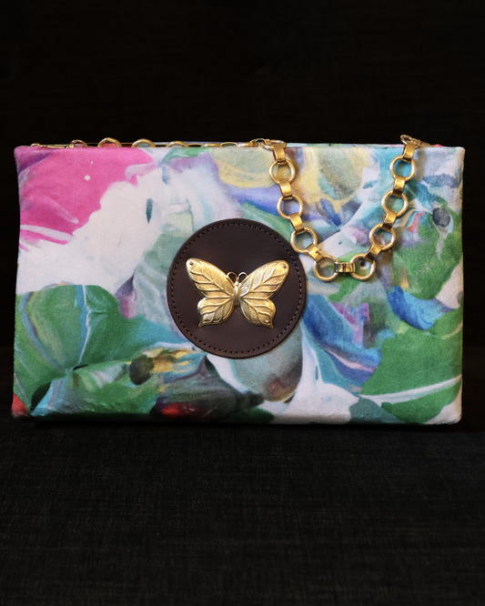 Colorful floral pouch with a brass chain and butterfly accent