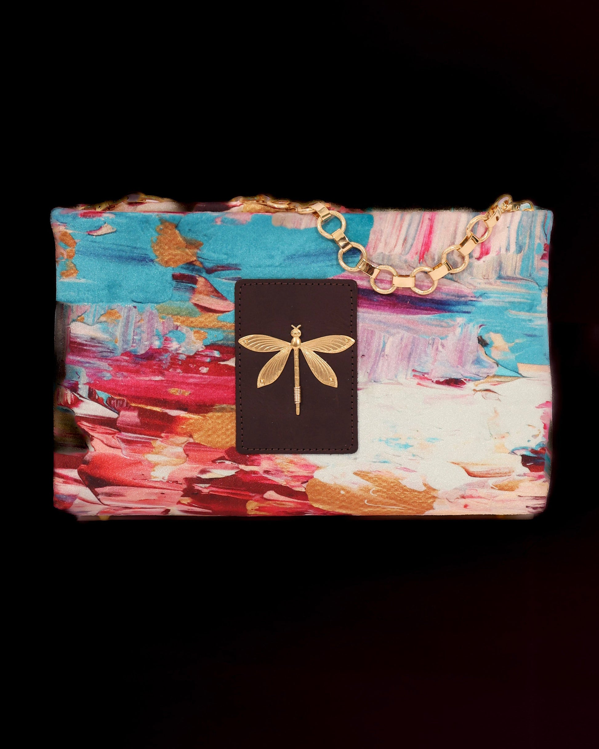 Colorful clutch bag with abstract design and brass chain and brass accent.